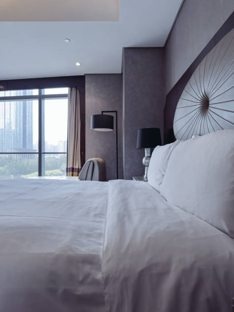 istock A luxurious and modern hotel room featuring a king-sized bed with crisp white linens, a stylish headboard, and elegant bedside lamps. 2188670007