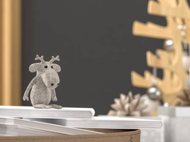 felt toy reindeer sitting on top of books in front of christmas gifts and decoration against a dark grey wall