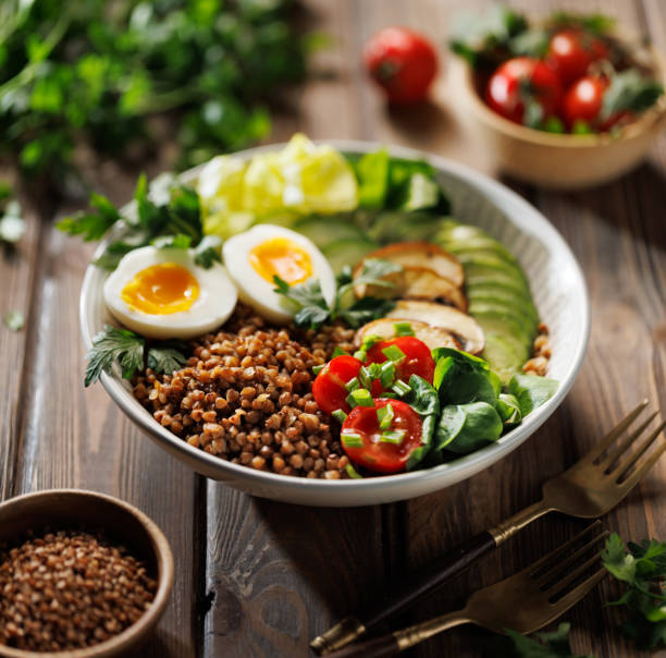 istock Buckwheat groats with avocado, various vegetables and soft-boiled egg in a ceramic bowl, focus on groats, shallow depth of field. 2188676169