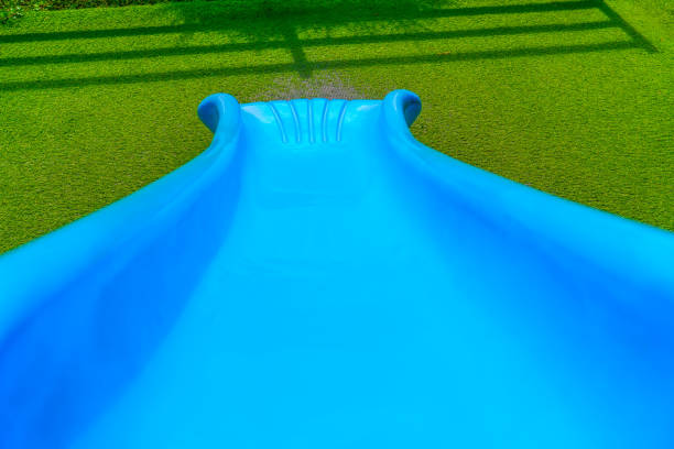 Blue children's slide in playground skate view down slope descent.