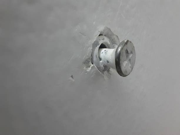 istock screw stuck in a white wall, a close-up view 2188680598