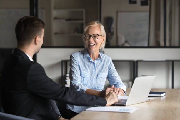 istock Aged woman and young man engaged in positive professional conversation 2188687945