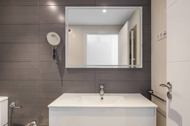 istock Modern bathroom with gray tiles, toilet and rectangular large mirror with lighting 2188688190