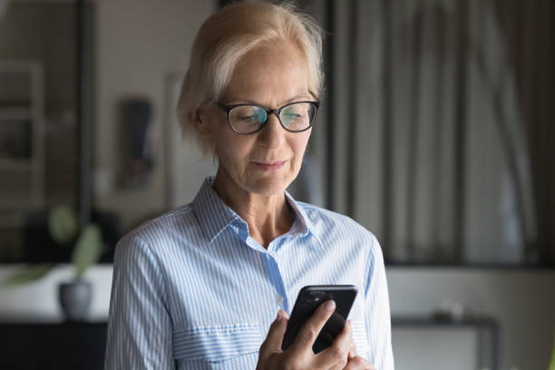 istock Focused mature businesswoman using smartphone at workspace 2188690389
