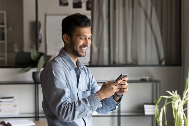 istock Satisfied Indian businessman using smartphone in office 2188691070
