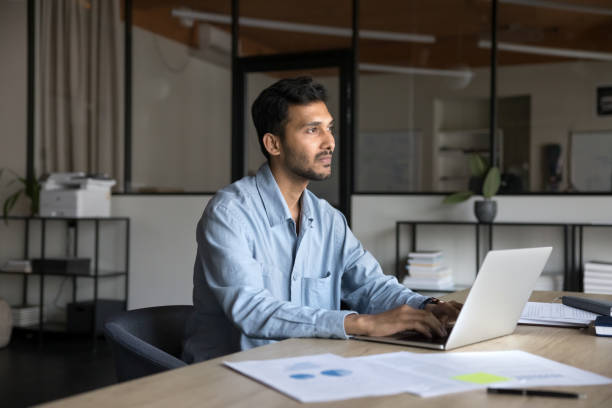 istock Pensive businessman, entrepreneur working on-line using laptop seated at workplace 2188691808