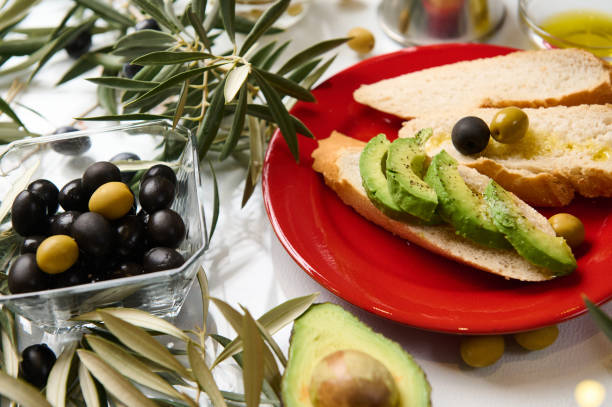 istock Mediterranean snack with avocado, olives, and bread on a red plate 2188692198