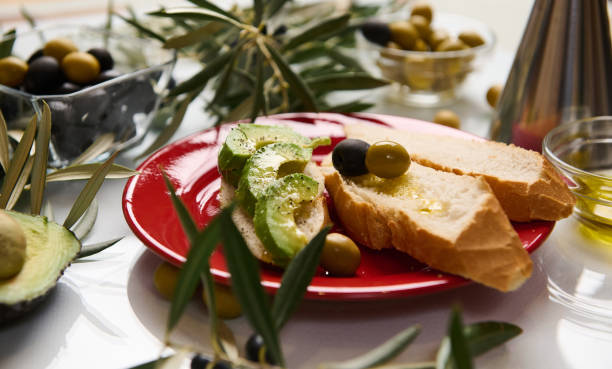 istock Avocado and olives on bread with olive oil on a red plate 2188692331