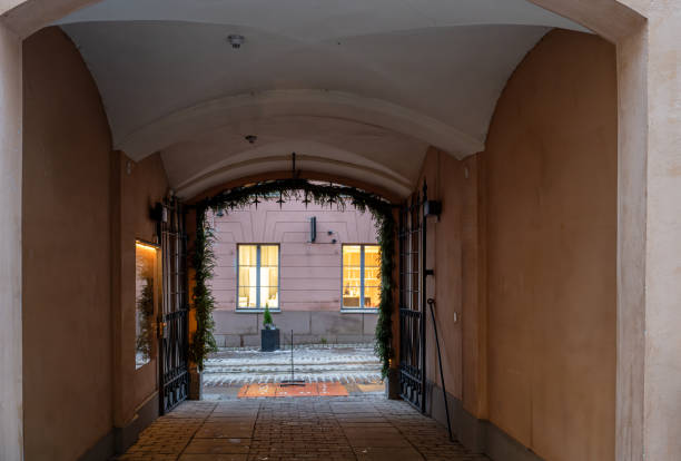 Cozy arched passageway with view of illuminated windows.