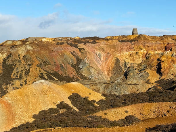 Extraordinary colours of copper in disused and ancient copper & zinc mine known as Parys Mountain on Welsh island of Anglesey. An old windmill used to vent the mine shafts is on the horizon. Open to the public without payment.