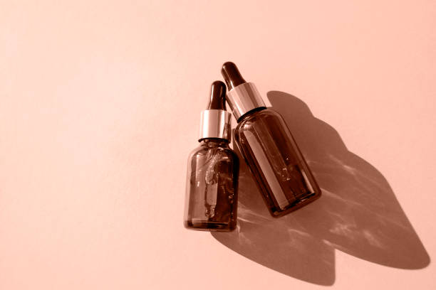 istock Glass dropper bottles on a beige background cast shadows.Flat lay, place for text. Cosmetic product. 2188706881