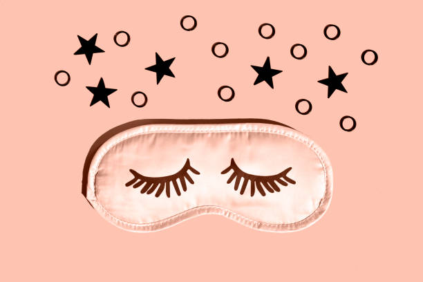 istock Pink sleep mask with eyelashes on a gray background with black stars. 2188706888