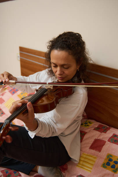 istock Woman practicing violin in bedroom for a calming musical session 2188708508