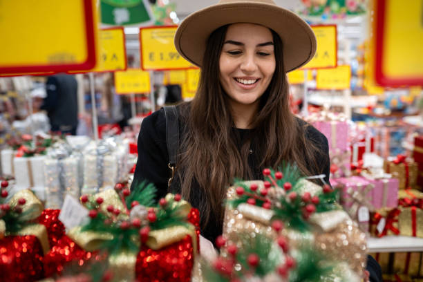 Young woman having a Christmas shopping in a big supermarket