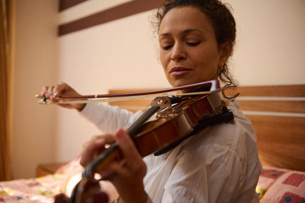 istock Woman gracefully playing the violin in a serene bedroom setting 2188708614