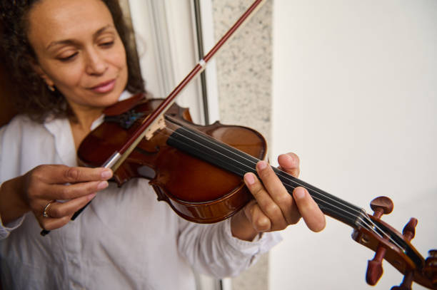 istock Woman playing the violin with focus and elegance by a window 2188708643