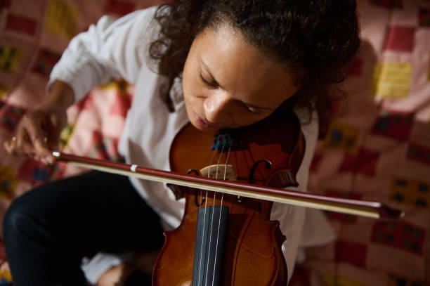 istock Woman focused on playing a violin in a cozy setting 2188708975