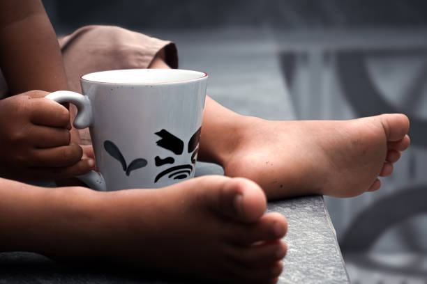 Boy's hand holding a mug filled with drink