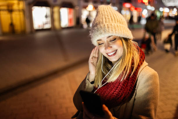 istock Woman Streaming Music on Smartphone During Holidays 2188716124