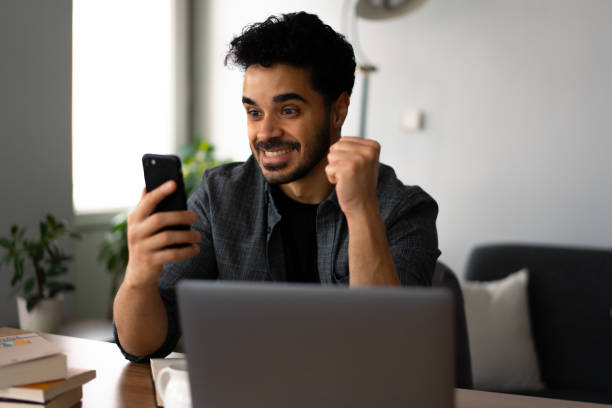 istock Excited university student celebrating success at home 2188721600