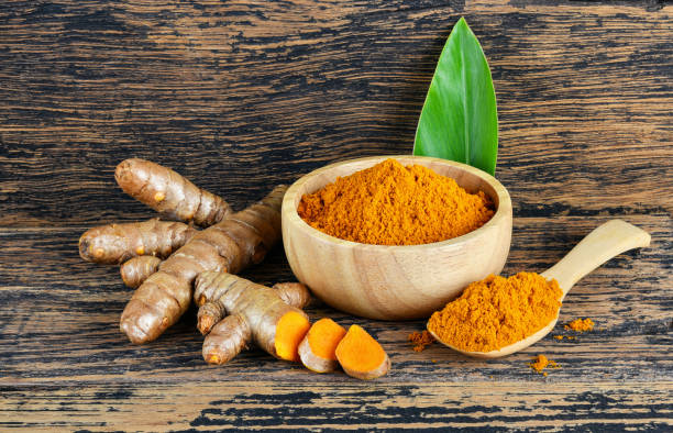 istock Turmeric roots with turmeric powder on wooden background 2188723832
