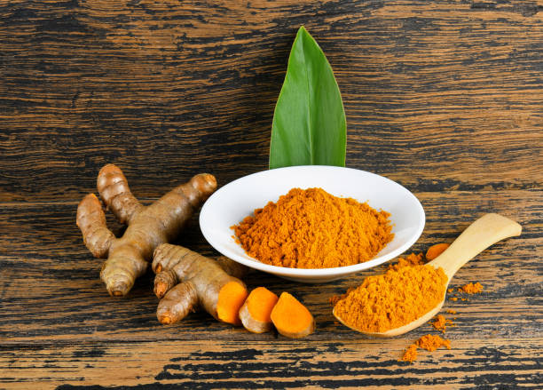 istock Turmeric powder and fresh turmeric on wooden background. 2188723873