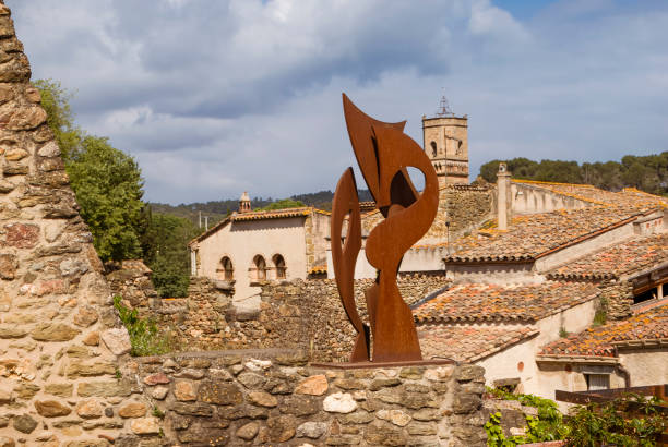 Monells, Spain, May 12th, 2013:Rustic Charm of Monells: Medieval Architecture and Modern Sculpture