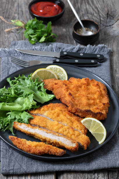 istock Pork Milanese with lettuce and lemon on a plate 2188740221