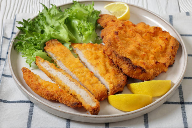 istock Pork Milanese with lettuce and lemon on a plate 2188741172