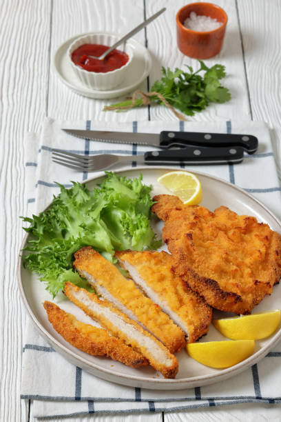 istock Pork Milanese with lettuce and lemon on a plate 2188741345