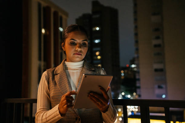 istock Woman looking at tablet at night on terrace 2188745742