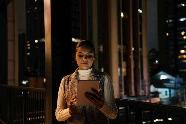 istock Woman looking at tablet at night on terrace 2188745761