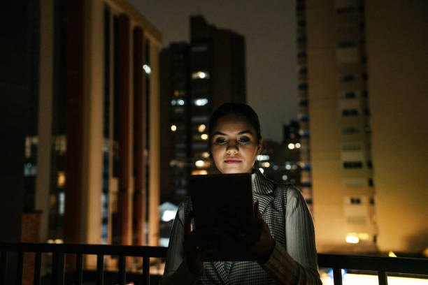 istock Woman looking at tablet at night on terrace 2188745808