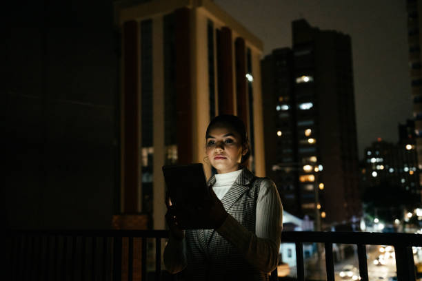 istock Woman looking at tablet at night on terrace 2188745820
