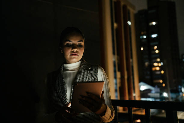 istock Woman looking at tablet at night on terrace 2188746733