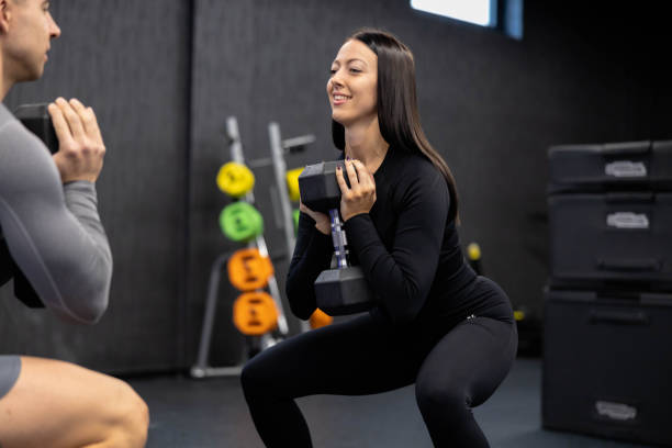 istock Confident woman with dumbbell focused in squat exercise. 2188749201