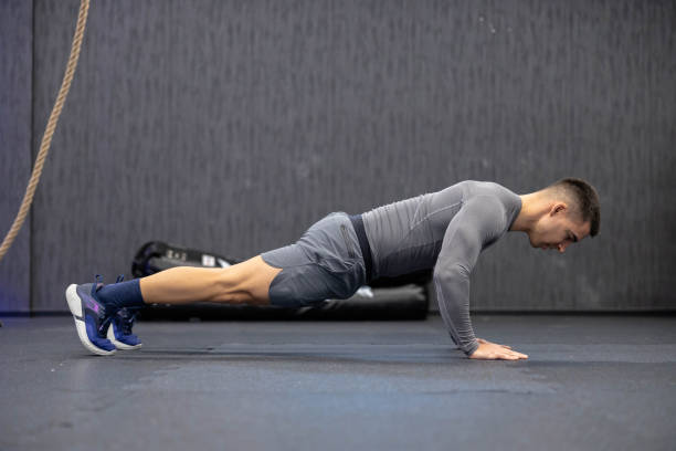 istock Side view of man dedicatedly doing perfect push-up. 2188749252