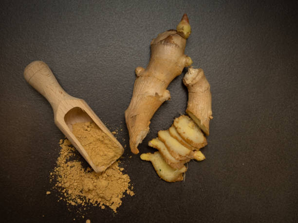 istock Warming ginger, root and ground with wooden spatula on dark background 2188749453