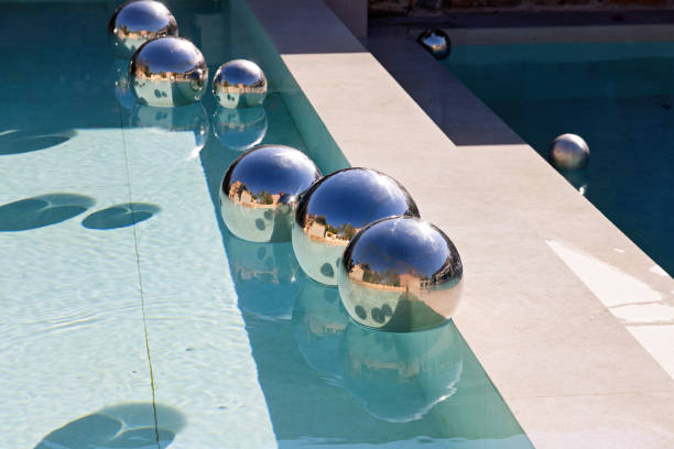 silver balls in the swimming pool that reflect sunlight and surroundings