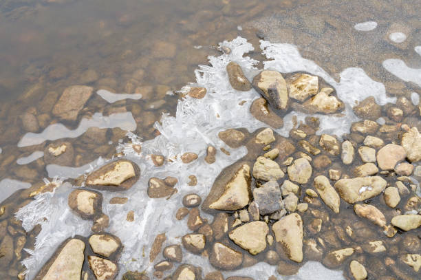 istock Sand-colored stones on the river bank in ice with a bizarre pattern, winter on the river. 2188764319