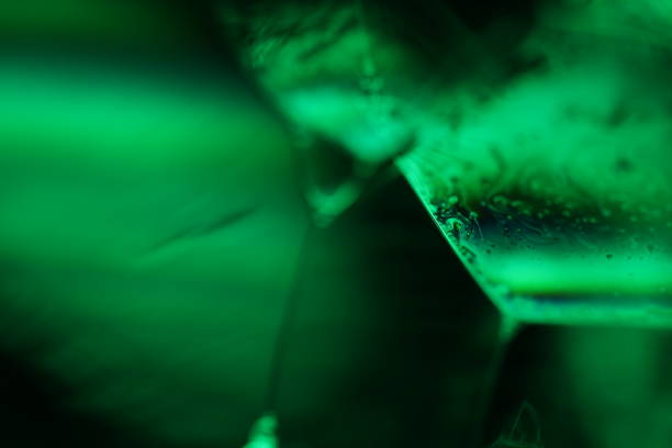 Green liquid surface on the dark background, colourful abstract, green shapes, minimalism, line of light