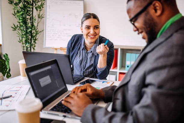 istock Business colleagues enjoying working together in office using wireless technology and smiling on a meeting 2188764628