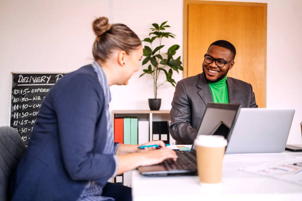 istock Business colleagues enjoying working together in office using wireless technology and having a coffee break while sitting on conference table 2188764682