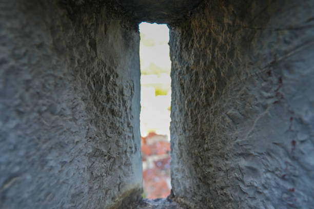 View of a tiny strip of the Bay of Kotor through a arrow slit in the wall of the San Giovanni Fortress in Kotor Montenegro