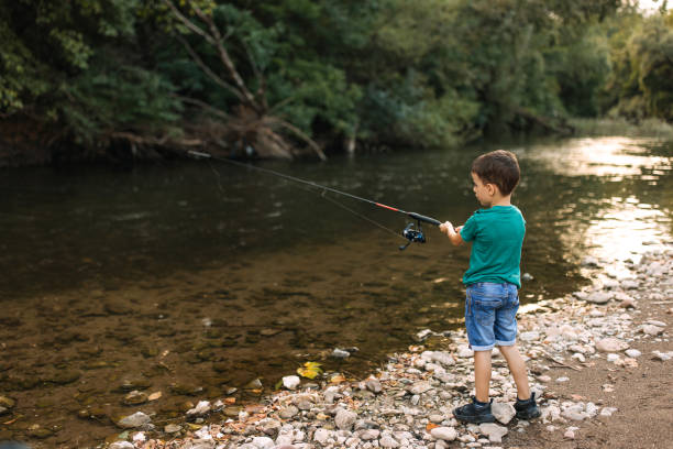 istock Boy is fishing from the shore. 2188771094