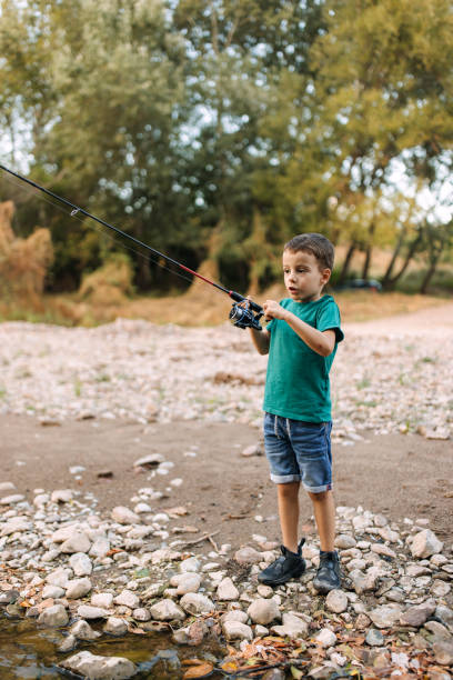 istock Boy is fishing from the shore. 2188771111