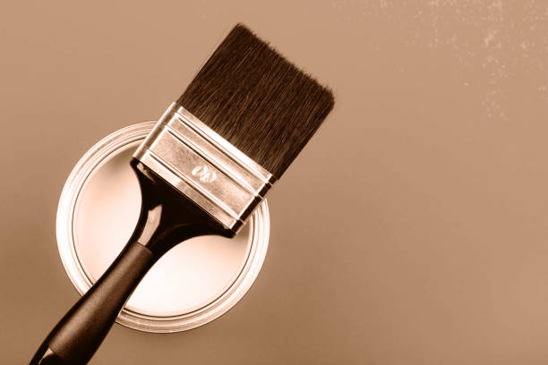 istock Paintbrush resting on a can with a warm, elegant tone background 2188789734