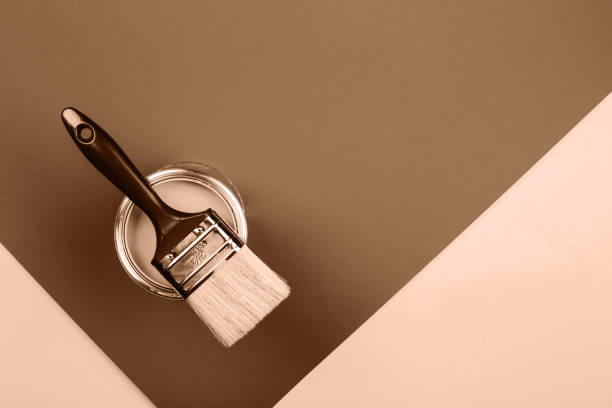 istock Paintbrush resting on open can against a two-tone brown background 2188790538