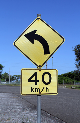 Turn Sign Speed Turn Left And Speed Limit Signs Mounted On A Single Pole Next To A Road ...