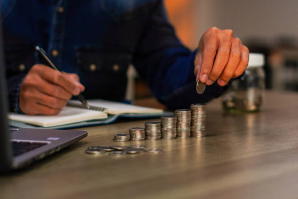 istock Young Asian man making stack of coin 2188792551